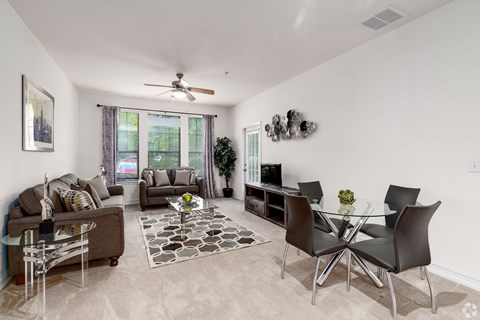 A living room with a glass table and chairs.