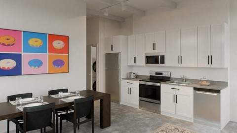A kitchen with a dining table and chairs in front of a wall with a colorful picture.