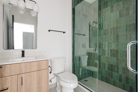 A bathroom with a toilet, sink, and shower.