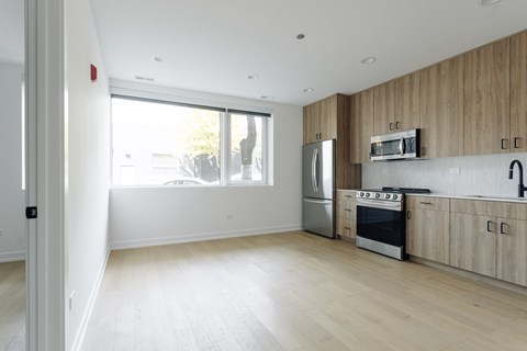A kitchen with wooden cabinets and a stainless steel refrigerator.