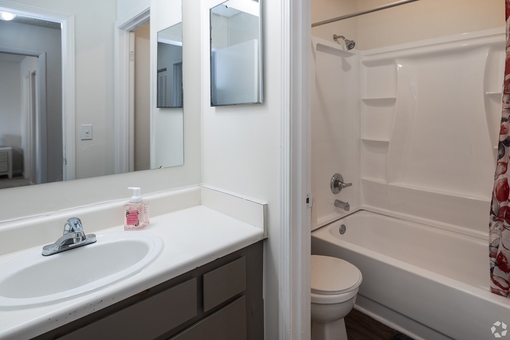 A white bathroom with a sink, toilet and bathtub.