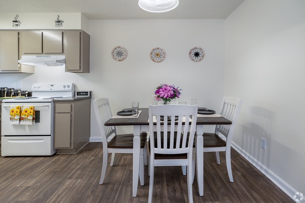 A kitchen with a table and chairs set for two.