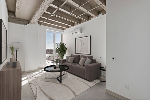 A living room with a brown couch and a framed picture on the wall.