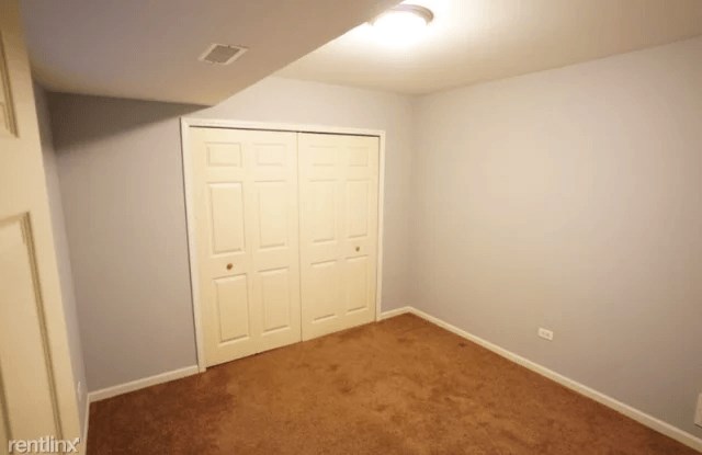 a room with a carpeted floor and two closets