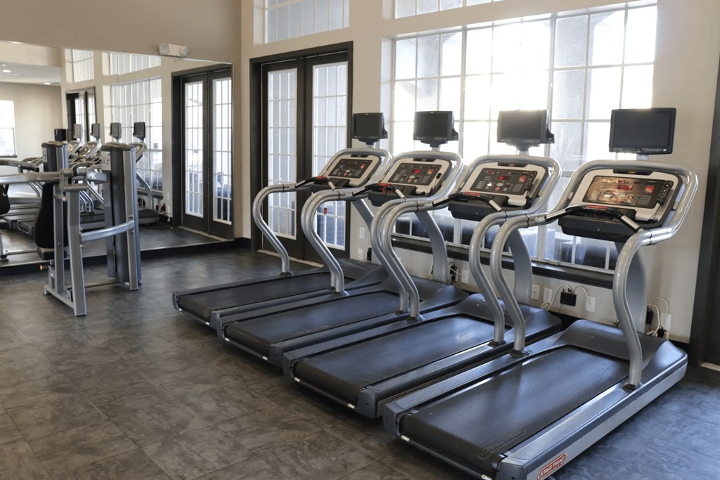 A gym with treadmills and elliptical machines.