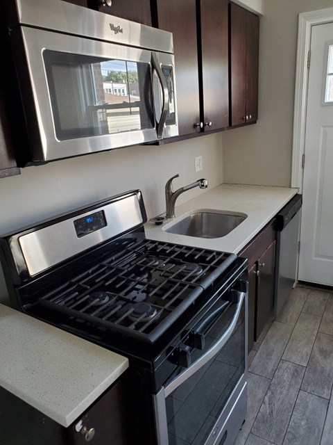 A modern kitchen with a stove top oven and microwave above it.