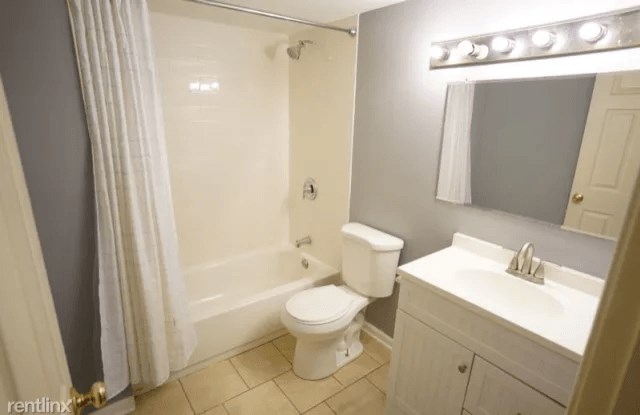 a bathroom with a toilet and a sink and a shower