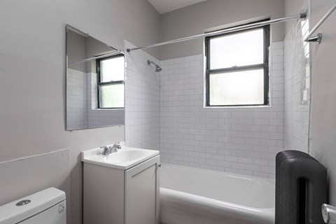 A white bathroom with a toilet, sink, and bathtub.