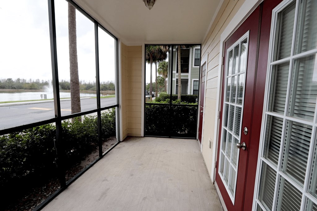 A balcony with a view of a body of water and trees.