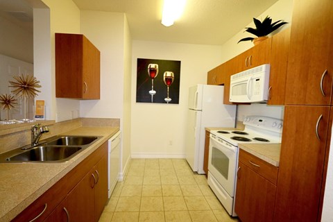 A kitchen with a fridge, microwave, and oven.