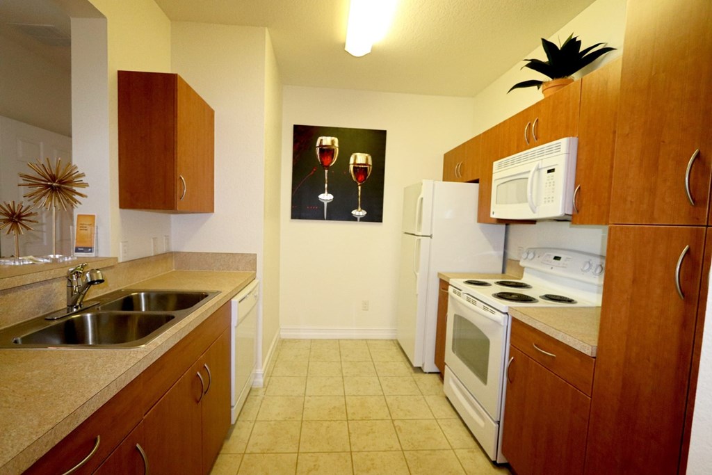 A kitchen with a fridge, microwave, and oven.