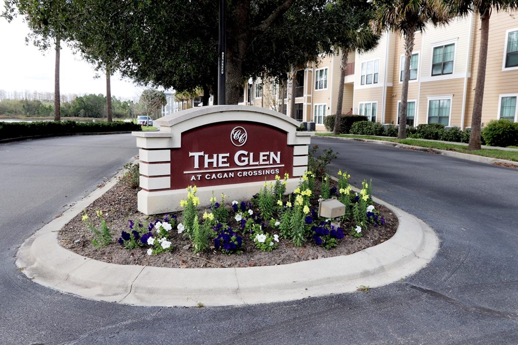 The sign for The Glen at Cagan Crossing is surrounded by flowers.