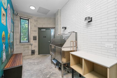 A kitchen area with a stainless steel oven and a white brick wall.