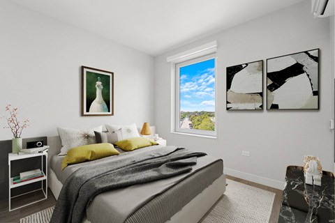 A bedroom with a large bed and a window showing a blue sky.