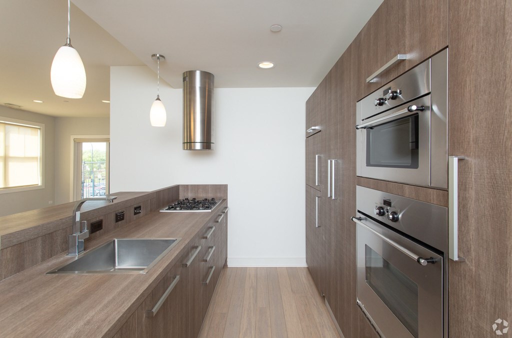 A modern kitchen with wooden cabinets and stainless steel appliances.