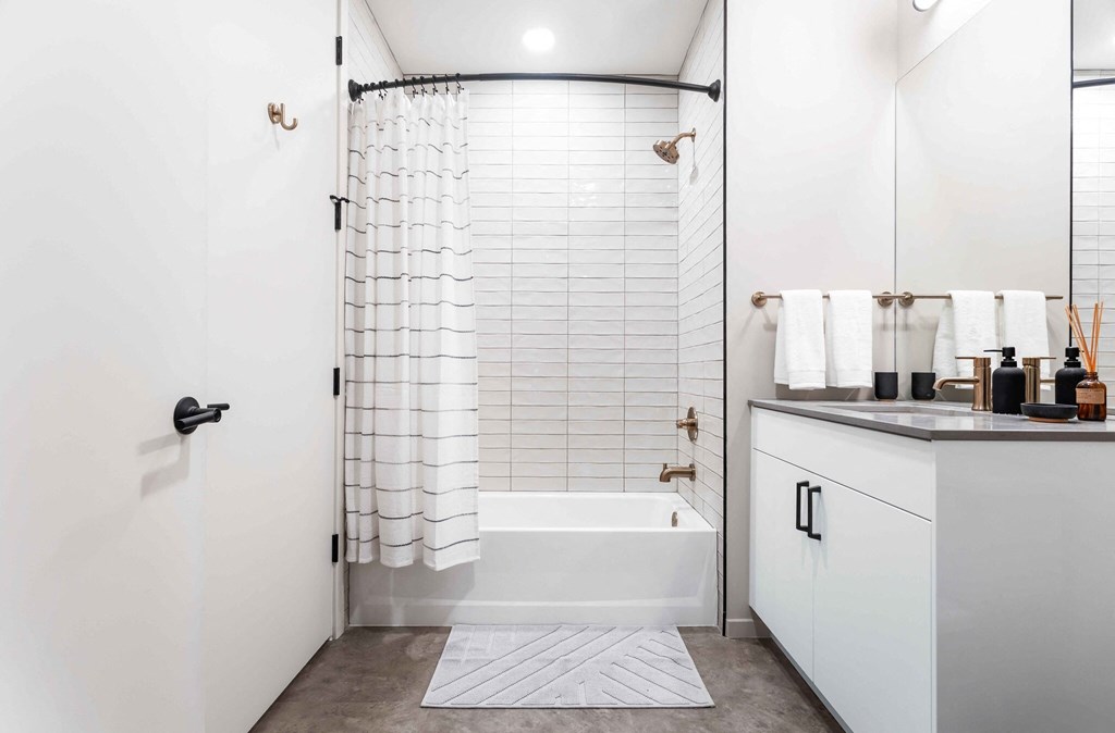 a white bathroom with a shower and a sink