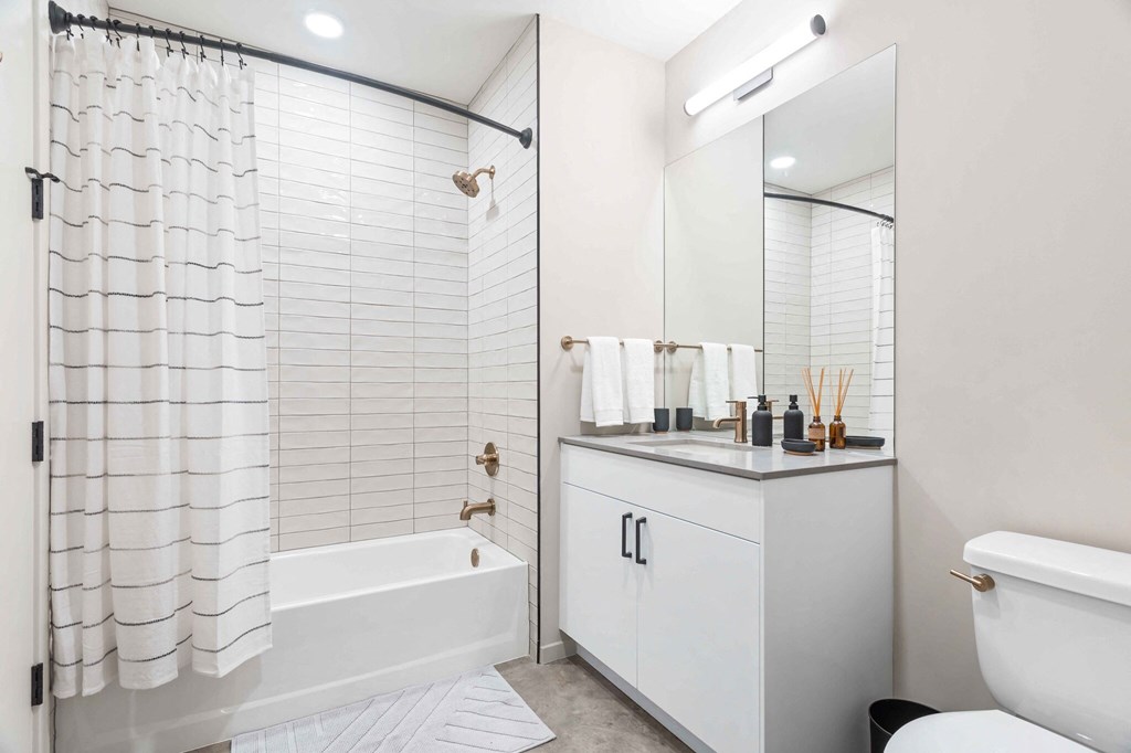a white bathroom with a shower and a sink