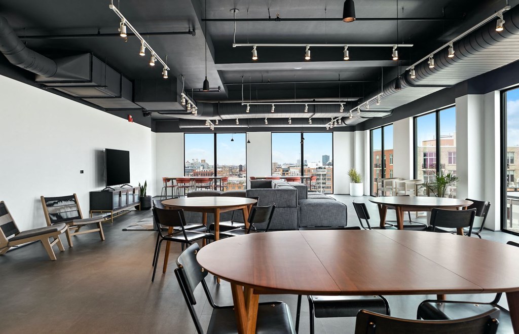 a large room with tables and chairs and large windows