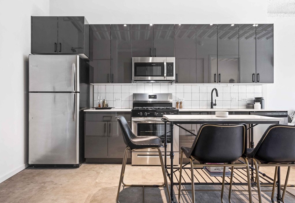 a kitchen with stainless steel appliances and a table with chairs