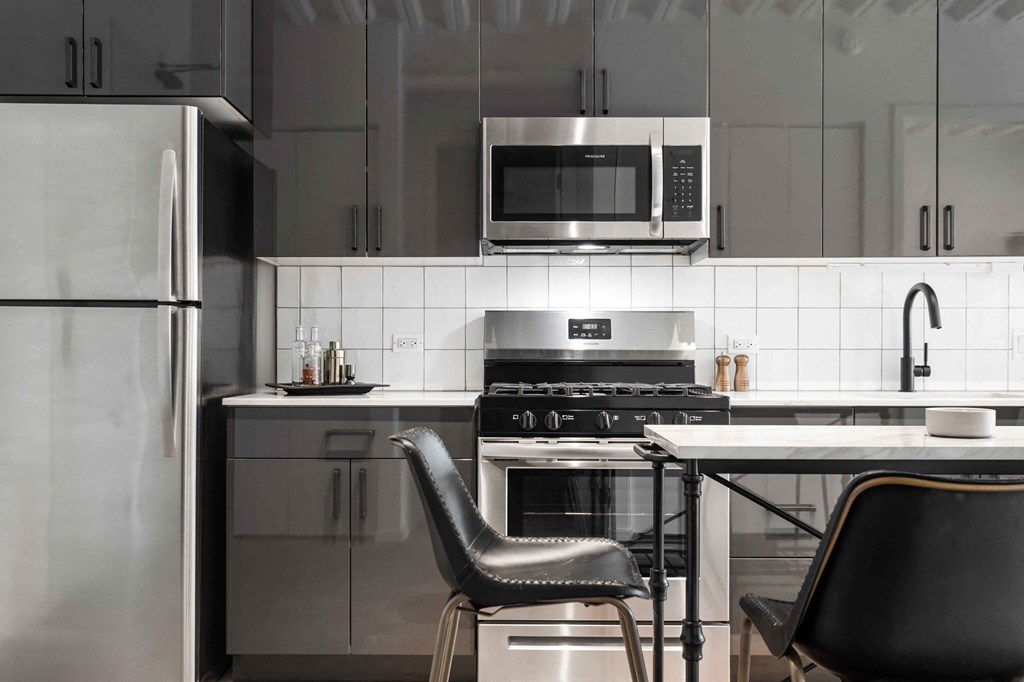 a kitchen with stainless steel appliances and a table and chairs