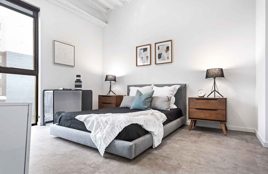 a bedroom with a bed and a large window