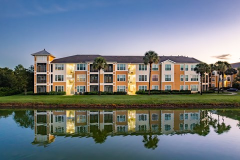 A large building with a reflection in the water in front of it.