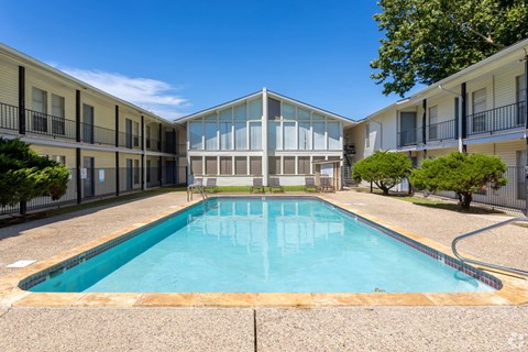 A swimming pool in a courtyard surrounded by buildings.