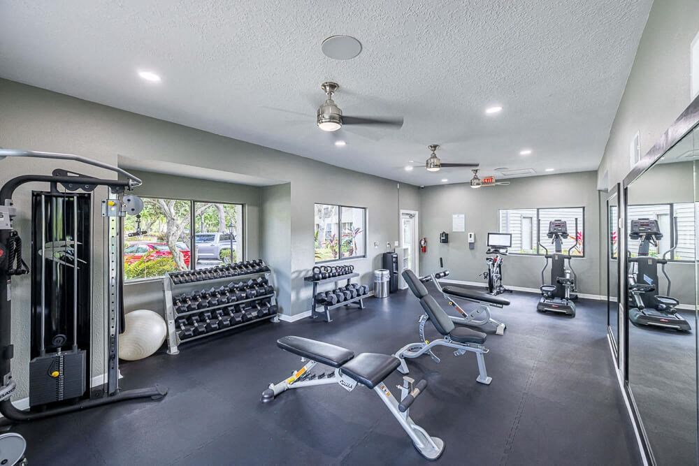 Fitness center with weightlifting equipment at Huntington Place Apartments in Sarasota, Florida