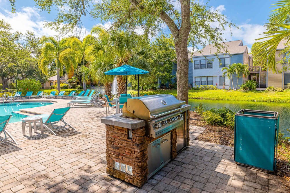 BBQ grill and picnic area near pool at Huntington Place Apartments in Sarasota, Florida