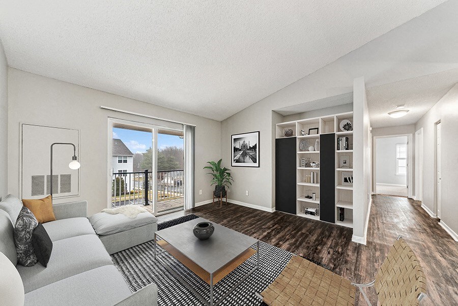 Model Living Room with Wood-Style Flooring and Patio Accessibility at Commons at Haynes Farm Apartments in Shrewsbury, MA.