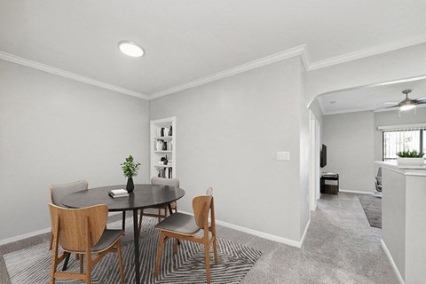 Model Dining Room with Carpet and View of Living Room at Hidden Creek Apartments located in Lewisville, TX.
