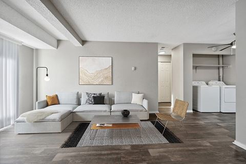 Model Living Room with Wood-Style Flooring and Washer/Dryer Hook Ups at Liberty Creek Apartments in Aurora, CO.