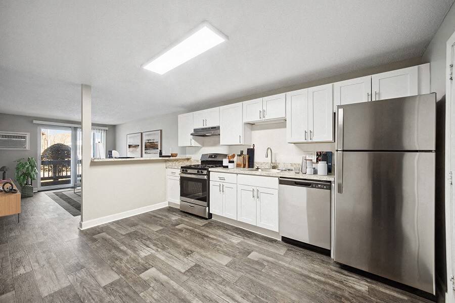 Model Kitchen with White Cabinets and Wood-Style Flooring at Middlesex Crossing Apartments in Billerica, MA.