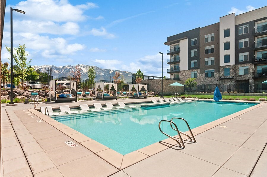Community Swimming Pool with Pool Furniture  at Seven Skies Apartments located in Sandy, UT.