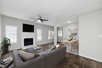 Model Living Room and Dining Room Area with Wood-Style Flooring at Heatherstone Apartments in Dallas, TX.
