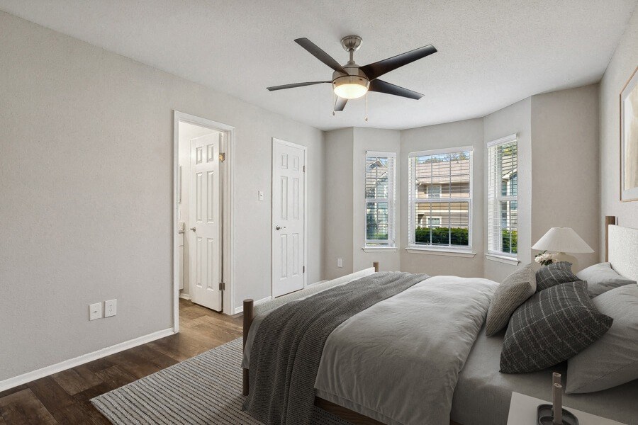 a bedroom with a bed and a ceiling fan