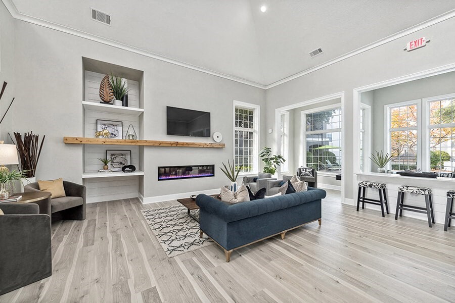 Community Clubhouse with Lounge Furniture and Fireplace at Bridges at Oakbend Apartments in Lewisville, TX.