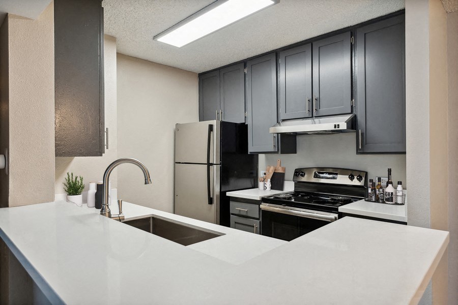 Model kitchen with dark cabinets and light countertops