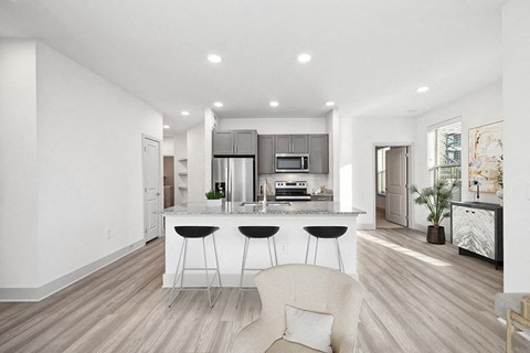Model Kitchen with Gray Cabinets and Wood-Style Flooring at Alta 3Eighty Apartments located in Aubrey, TX.