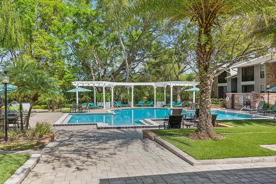 Community Swimming Pool with Pool Furniture at Grand Pavilion Apartments in Tampa, FL.