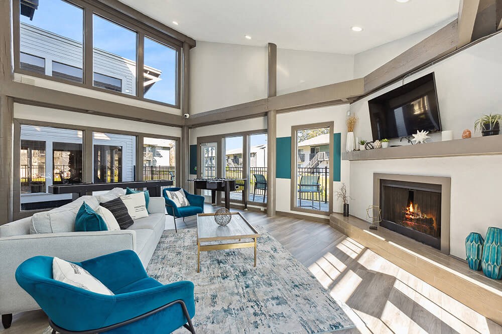 Community Clubhouse with Lounge Furniture and Fireplace at Seven Lakes at Carrollwood Apartments in Tampa, FL.