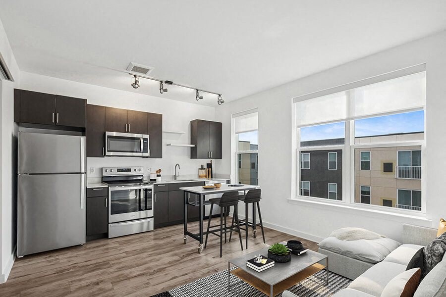 Model Kitchen with Dark Wood Cabinets and Wood-Style Flooring at Stella Apartments located in New Carrollton, MD.