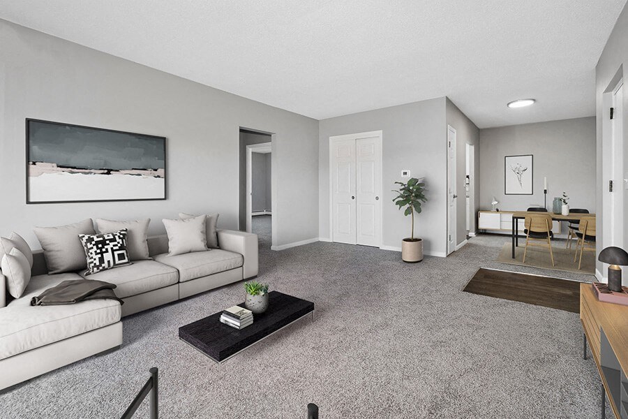 Model Living Room with Carpet and View of Dining Room at Stone Ends Apartments in Stoughton, MA.
