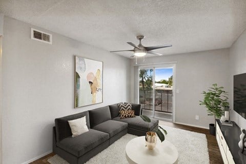 a living room with a couch and a ceiling fan