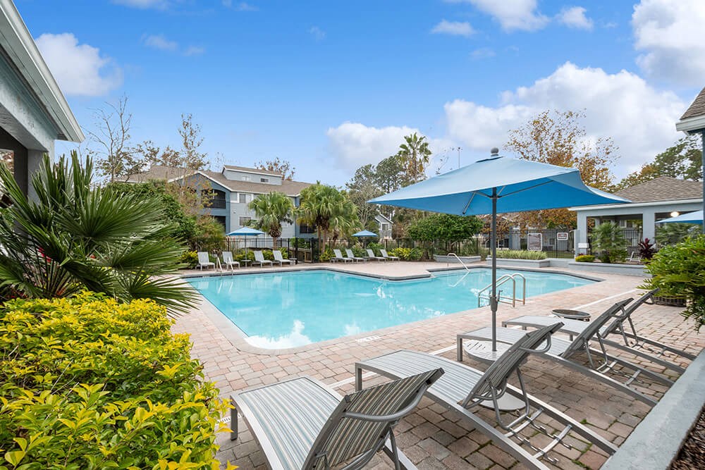 Community Swimming Pool with Pool Furniture at Westland Park Apartments in Jacksonville, FL.