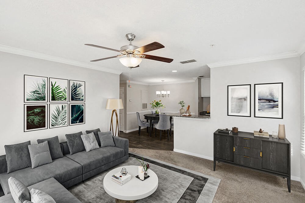 Model Living Room with Carpet and View of Dining Room with Wood-Style Flooring at Shadow Ridge Apartments in Riverdale, GA.