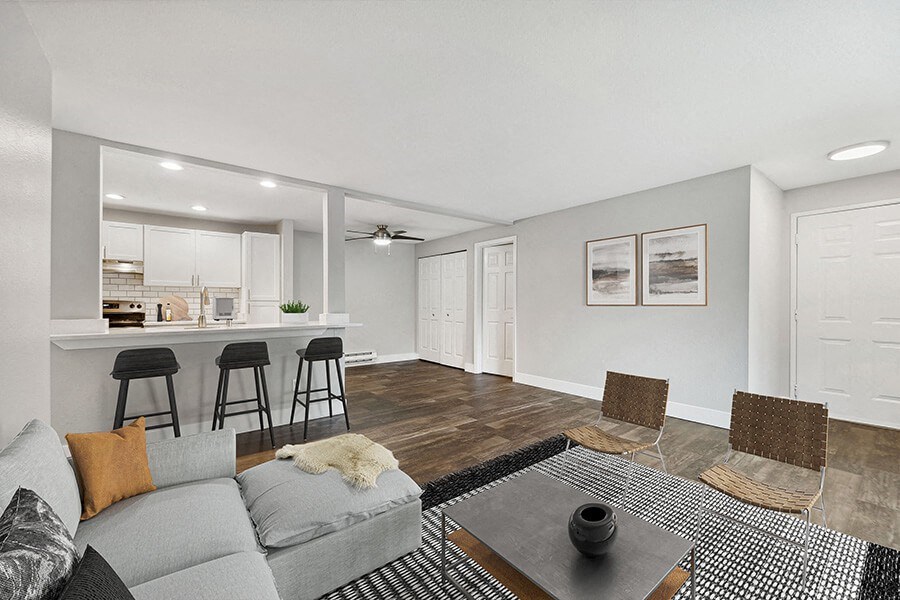 Model Living Room with Wood-Style Flooring and View of Kitchen at Central Flats Apartments in Kent, WA.