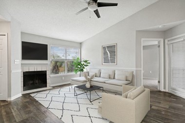 Model living room with fireplace and ceiling fan