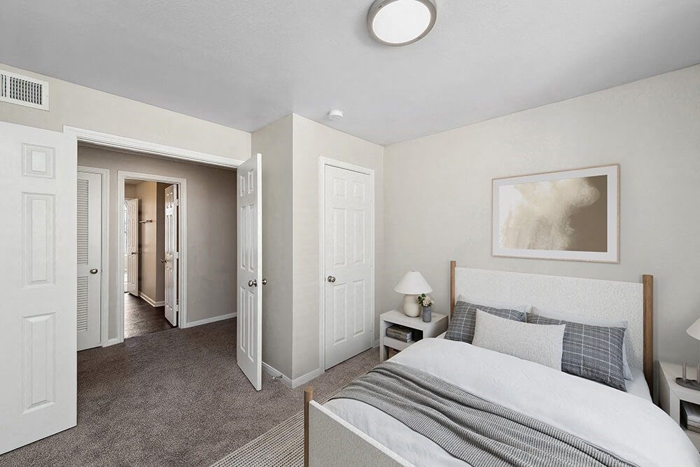 Model Bedroom with Carpet and Hallway View at Hidden Creek Apartments in Lewisville, TX.