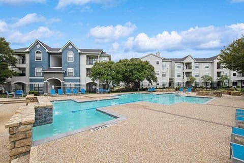 Community Swimming Pool with Pool Furniture at Hidden Creek Apartments located in Lewisville, TX.